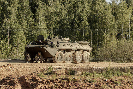 Стрелки прячутся за БТР-82А на дороге в лесу. Военные учения армии России. (2018 год). Редакционное фото, фотограф Евгений Зимин / Фотобанк Лори