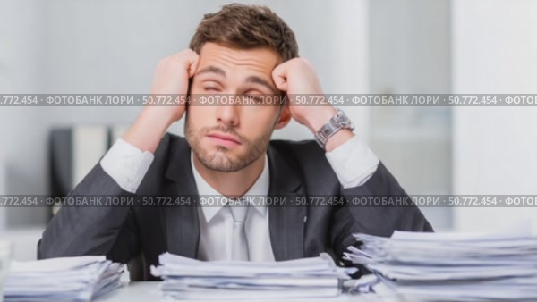 Stressed businessman holding head with documents at office desk. Стоковое AI-видео, аниматор Юрий Поздников / Фотобанк Лори