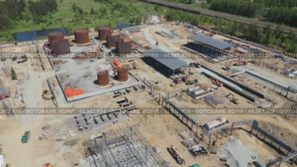 Строительство резервуара для нефтехранилища методом полистовой сборки. Вид сверху. Полет вокруг стройплощадки. Стоковое видео, видеограф Евгений Ткачёв / Фотобанк Лори