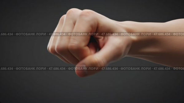 Strong fist showing determination against a dark background. Стоковое AI-видео, аниматор KATERINA AI / Фотобанк Лори