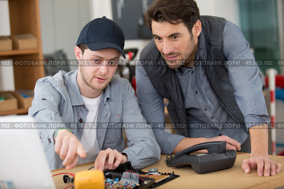 student technician with dismantled telephone. Стоковое фото, агентство Ingram Publishing / Фотобанк Лори