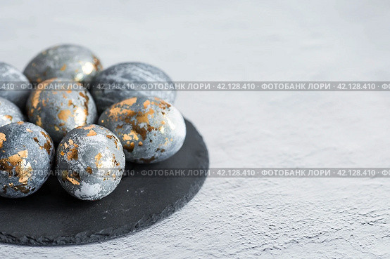 Stylish grey Easter eggs made of marble and concrete with a golden potala on a grey background. Coloring eggs with natural dye karkade tea. . The concept of a happy Easter. Стоковое фото, фотограф Photojuli / Фотобанк Лори