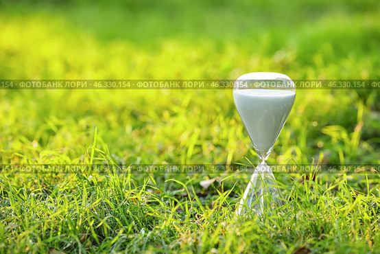 Stylish hourglass on grass outdoors. Стоковое фото, фотограф Pixel_shot / Фотобанк Лори