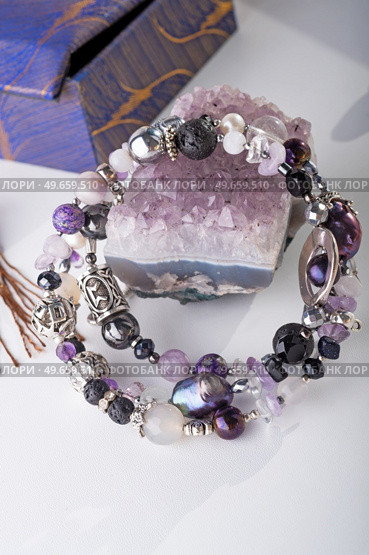 stylish jewelry bracelet with semiprecious and amethyst  crystal around  white background. hobby and fashion concept. close up. Стоковое фото, агентство Ingram Publishing / Фотобанк Лори