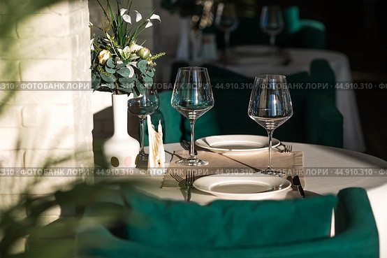 Stylish table setting. Glass glasses, plates, cutlery on the table. Wedding service, reception at the dining table. A birthday, a baptism, a festive event. Стоковое фото, фотограф Photojuli / Фотобанк Лори