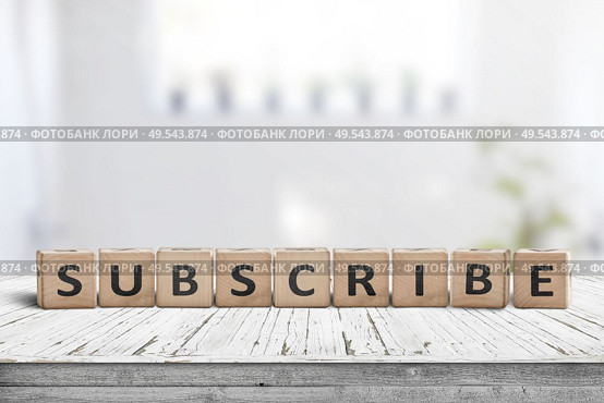 Subscribe word on a wooden sign on a table in a bright room. Стоковое фото, агентство Ingram Publishing / Фотобанк Лори