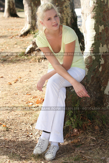 Summery woman sitting by a tree. Стоковое фото, агентство Ingram Publishing / Фотобанк Лори