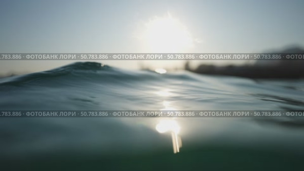 Sun reflecting on gentle waves at dawn. Стоковое видео, видеограф Данил Руденко / Фотобанк Лори