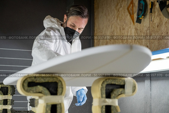 Surfboard manufacturing, Shaper working on board details. Concept of industrial manufacturing, qualified professional, occupation and employment. Стоковое фото, агентство Ingram Publishing / Фотобанк Лори