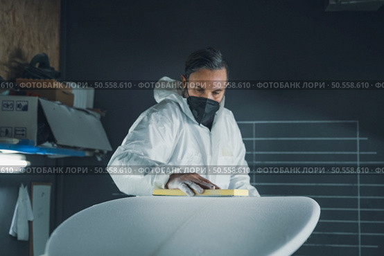 Surfboard manufacturing, Shaper working on board details. Concept of industrial manufacturing, qualified professional, occupation and employment. Стоковое фото, агентство Ingram Publishing / Фотобанк Лори