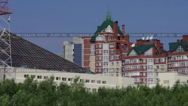 Сургут. Парк через Сайму - вид на здание Тюменьэнерго. Surgut. Park Across the Saima - view of the building of Tyumenenergo. (2015 год). Стоковое видео, видеограф Евгений Романов / Фотобанк Лори