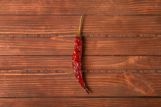 Сушеный жгучий перец на коричневом деревянном фоне. Стоковое фото, фотограф Pixel_shot / Фотобанк Лори