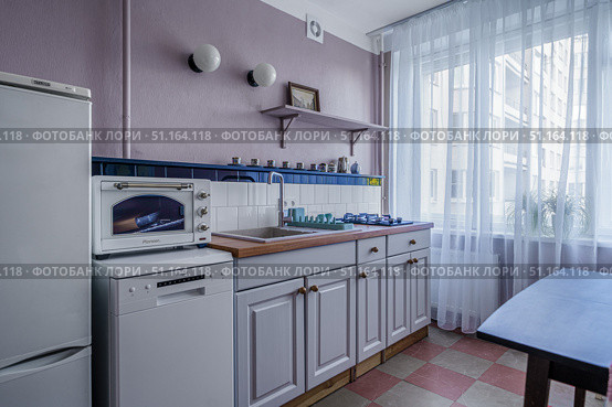 Светлая кухня с техникой у окна в городской квартире. Стоковое фото, фотограф Ремизова Алла Сергеевна / Фотобанк Лори