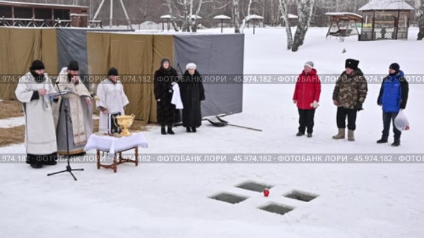 Священнослужители проводят церемонию освящения проруби на Крещение. Редакционное видео, видеограф Александр Тараканов / Фотобанк Лори