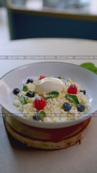 Sweet cheese dessert revealing delicate Eastern European flavor, garnished with vibrant berries and fresh mint, presenting elegant culinary craftsmanship on white ceramic plate. Стоковое видео, видеограф Данил Руденко / Фотобанк Лори