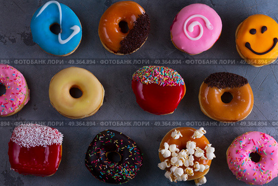 sweet doughnuts on gray stone background. sweet doughnuts putters on gray stone background, top view. Стоковое фото, агентство Ingram Publishing / Фотобанк Лори
