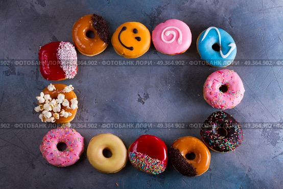 sweet doughnuts on gray stone background. sweet doughnuts on gray background, frame with copy space. Стоковое фото, агентство Ingram Publishing / Фотобанк Лори