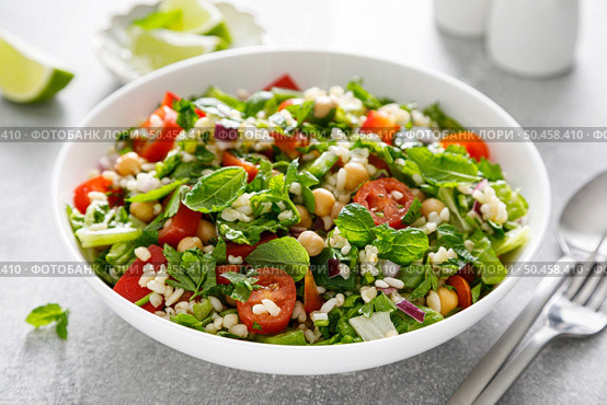 Tabbouleh salad. Tabouli salad with fresh parsley, onions, tomatoes, bulgur and chickpea. Healthy vegetarian food, mediterranean diet. Стоковое фото, агентство Ingram Publishing / Фотобанк Лори