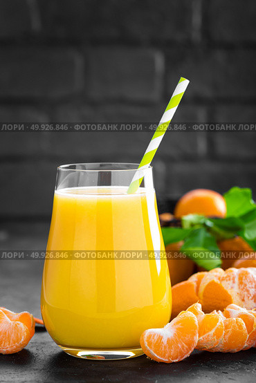 Tangerines, peeled tangerines and tangerine juice in glass. Mandarine juice and fresh fruits with leaves. Стоковое фото, агентство Ingram Publishing / Фотобанк Лори