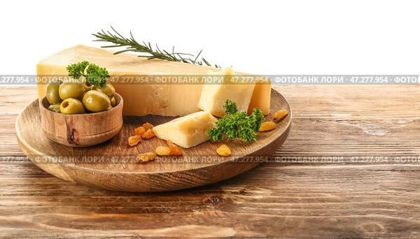 Тарелка с кусочками вкусного сыра пармезан и зелеными оливками на столе на белом фоне. Стоковое фото, фотограф Pixel_shot / Фотобанк Лори