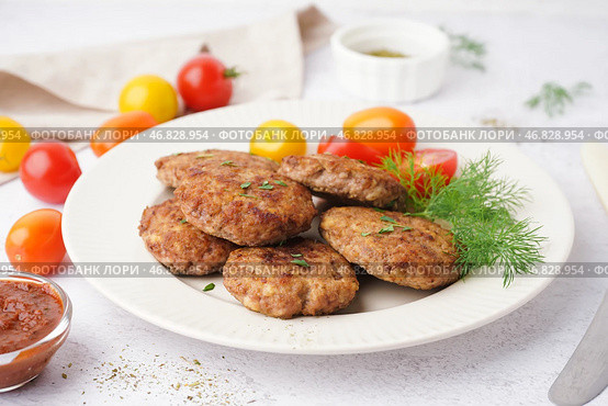 Тарелка с отбивными, укропом и помидорами на белом грунджевом столе на кухне. Стоковое фото, фотограф Pixel_shot / Фотобанк Лори