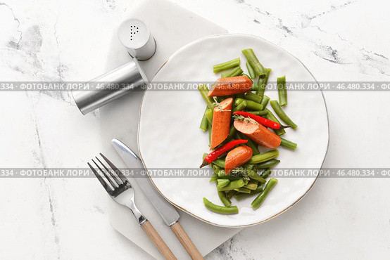 Тарелка с вкусной колбасой, стручковой фасолью и перцем чили на светлом фоне. Стоковое фото, фотограф Pixel_shot / Фотобанк Лори