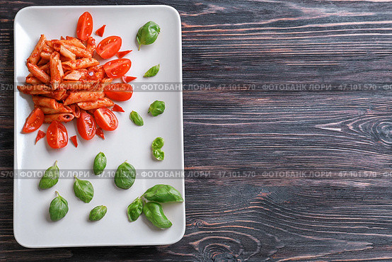 Тарелка с вкусной пастой пенне и гарниром на деревянном фоне. Стоковое фото, фотограф Pixel_shot / Фотобанк Лори