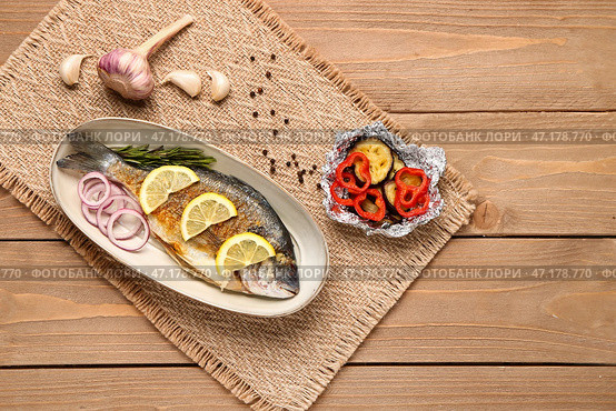 Тарелка с вкусной жареной рыбой дорадо на деревянном фоне. Стоковое фото, фотограф Pixel_shot / Фотобанк Лори