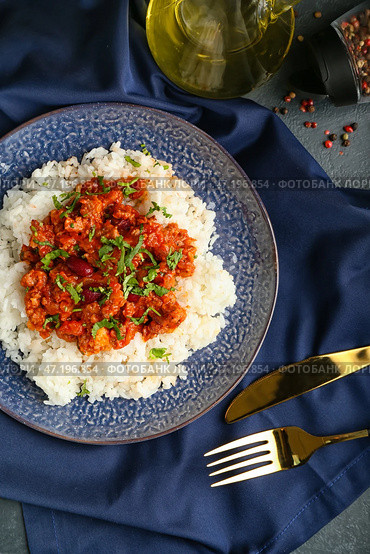Тарелка с вкусным чили кон карне и рисом на темном фоне. Стоковое фото, фотограф Pixel_shot / Фотобанк Лори