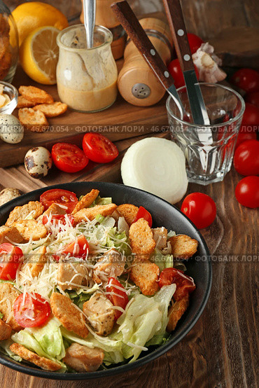 Тарелка с вкусным салатом Цезарь на деревянном столе. Стоковое фото, фотограф Pixel_shot / Фотобанк Лори