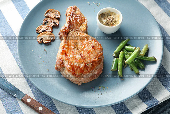 Тарелка с вкусным жареным стейком, гарниром и соусом на столе. Стоковое фото, фотограф Pixel_shot / Фотобанк Лори