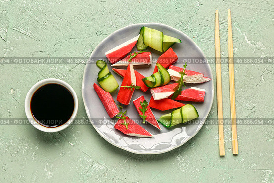 Тарелка с вкусными крабовыми палочками и соусом на светлом фоне. Стоковое фото, фотограф Pixel_shot / Фотобанк Лори