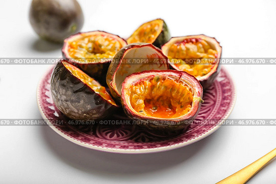 Тарелка с вкусными нарезанными маракуйями на белом фоне. Стоковое фото, фотограф Pixel_shot / Фотобанк Лори