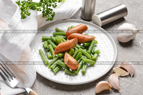 Тарелка с вкусными сосисками и стручковой фасолью на фоне гранж, крупным планом. Стоковое фото, фотограф Pixel_shot / Фотобанк Лори