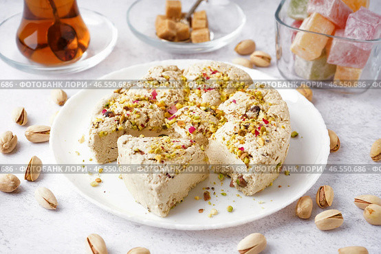 Тарелка вкусной халвы тахини с фисташками на светлом фоне. Стоковое фото, фотограф Pixel_shot / Фотобанк Лори