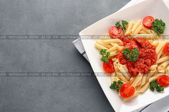 Тарелка вкусной пасты с соусом Болоньезе на столе. Стоковое фото, фотограф Pixel_shot / Фотобанк Лори