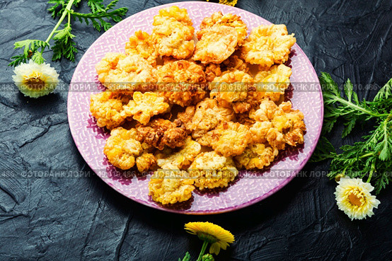 Tasty fried edible flowers. Chrysanthemum flowers in batter.Deep fried flowers. Chrysanthemum flowers roasted in batter. Стоковое фото, агентство Ingram Publishing / Фотобанк Лори