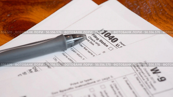 Tax form 1040 and W9 on a table, shallow depth of field. Стоковое фото, агентство Ingram Publishing / Фотобанк Лори