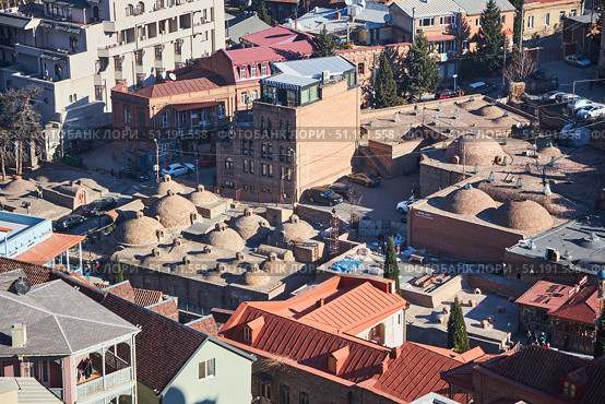 Tbilisi, Georgia - January 04, 2023: Old City Center. View of the ancient baths from the Narikala fortress. Редакционное фото, фотограф Наталия Кирсанова / Фотобанк Лори