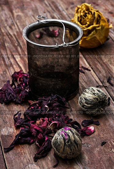 tea strainer and different varieties of tea leaves on wooden background.The toned image. Стоковое фото, агентство Ingram Publishing / Фотобанк Лори