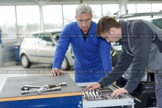 teacher and student choosing appropriate tools in mechanic school. Стоковое фото, агентство Ingram Publishing / Фотобанк Лори