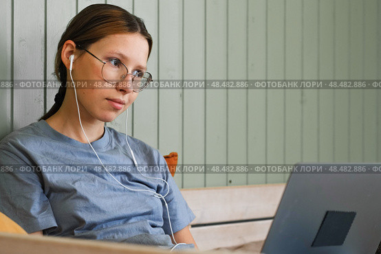 Teen girl school student wear headphones watching online webinar, talking through webcam looking at laptop. Teenager conducting video conference on computer at home, chatting online with friends. 4K. Стоковое фото, фотограф Марина Демидюк / Фотобанк Лори