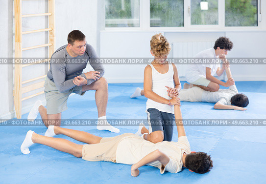 Teenager applying armlock technique to face-down opponent at self-defense classes. Стоковое фото, фотограф Яков Филимонов / Фотобанк Лори