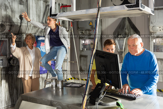 Teenager together with grandfather looking for puzzle solution in quest room. Стоковое фото, фотограф Яков Филимонов / Фотобанк Лори