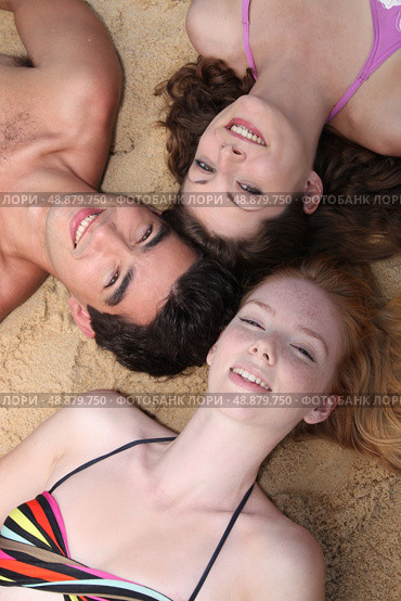 Teenagers lying on the sand. Стоковое фото, агентство Ingram Publishing / Фотобанк Лори