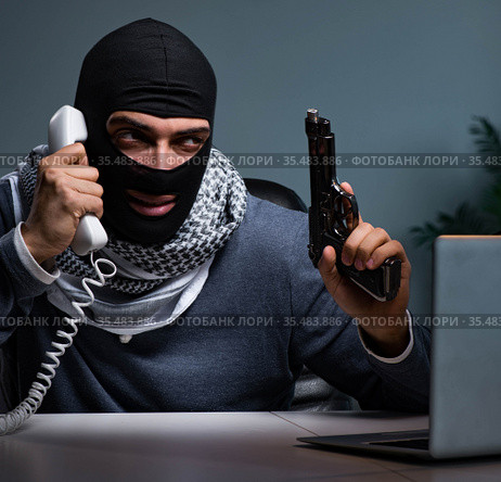 Terrorist burglar with gun working at computer. Стоковое фото, фотограф Elnur / Фотобанк Лори