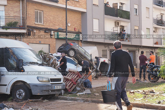The aftermath of hurricane Dana in Valencia, Spain - Devastating aftermath of flooding in Valencia, cars piled up and debris scattered across streets. Стоковое фото, фотограф Данил Руденко / Фотобанк Лори