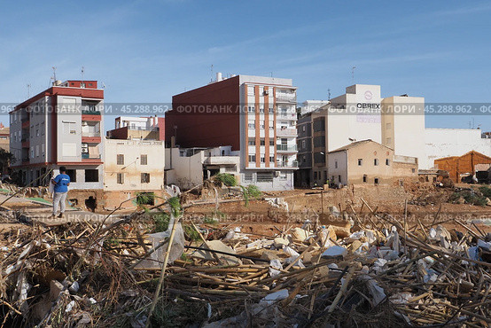 The aftermath of hurricane Dana in Valencia, Spain - Volunteer assessing damage after devastating flood in Valencia, Spain. Стоковое фото, фотограф Данил Руденко / Фотобанк Лори