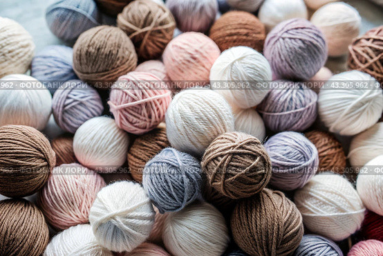 The background is made of balls of wool yarn . Needlework, textiles, knitting. Winter season, small business, handmade clothes. Стоковое AI-изображение, AI-художник Photojuli / Фотобанк Лори