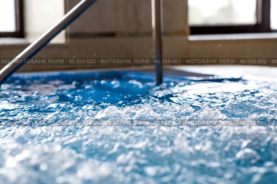 The banner. A swimming pool with hot blue thermal water with bubbles and a metal staircase. The concept of relaxation, spa and relaxation in a resort hotel. Tourism. Стоковое фото, фотограф Photojuli / Фотобанк Лори